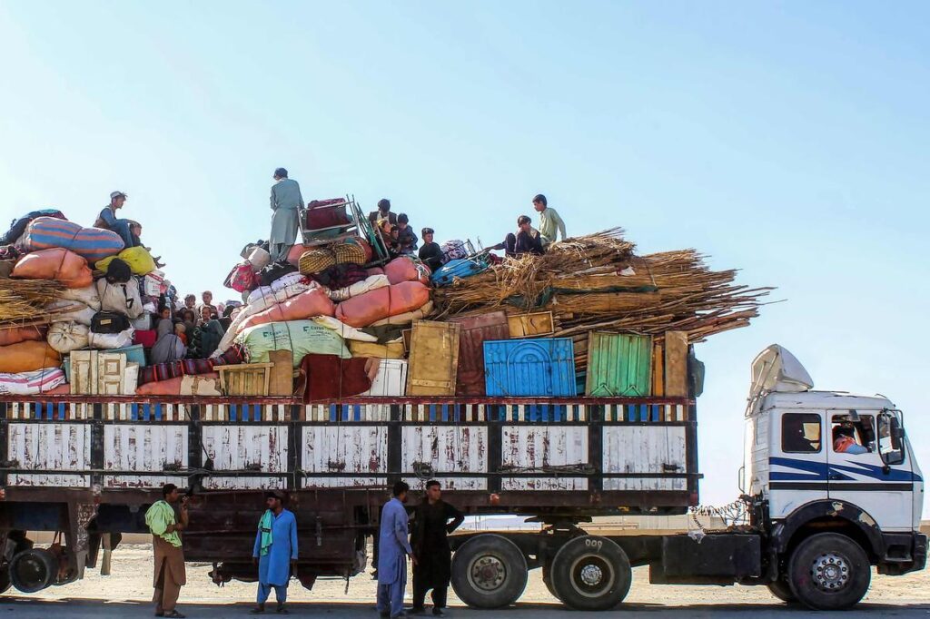 Afghan refugees sit atop a truck loaded with their belongings while waiting to cross the Pakistan–Afghanistan border at Chaman on October 13, amid ongoing deportations from Pakistan. (PC: AFP)