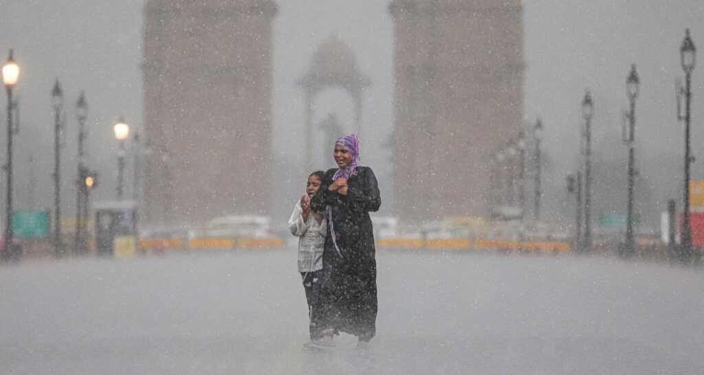 Commuters navigate waterlogged streets near Connaught Place as heavy rain lashes Delhi-NCR. IMD has issued an orange alert warning of thunderstorms and strong winds across the region. (PC: NewsArena)