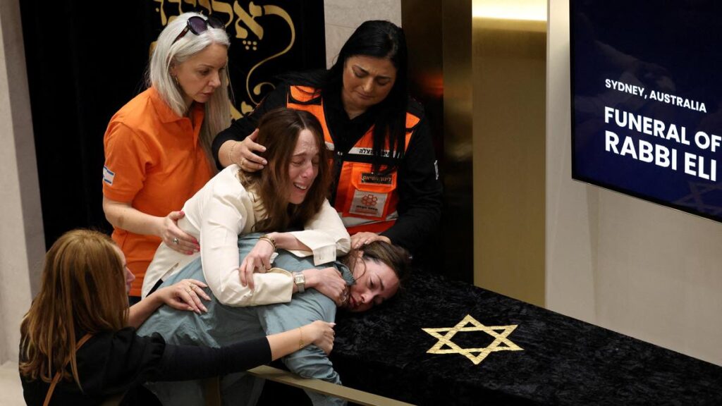 Family members of Rabbi Eli Schlanger, who was killed during a shooting at a Jewish Hanukkah celebration at Sydney's Bondi Beach on December 14, 2025, react as they lean over his casket during a funeral at Chabad of Bondi, in Sydney, Australia. (PC: Reuters)